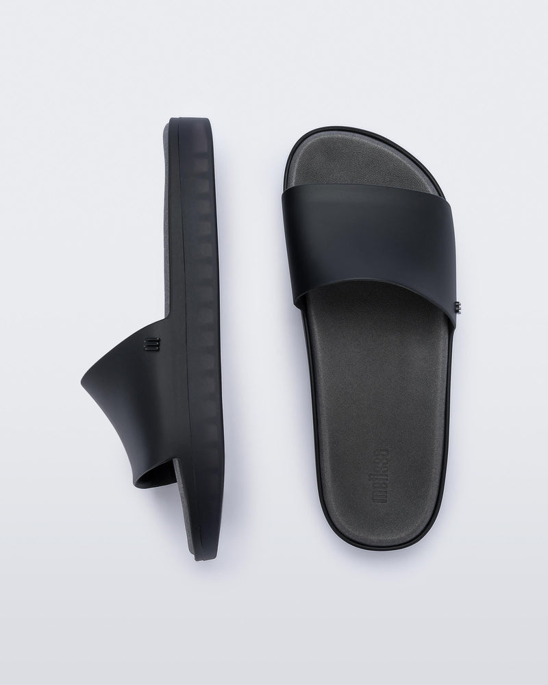 Top and side view of a pair of black Melissa Beach slides.