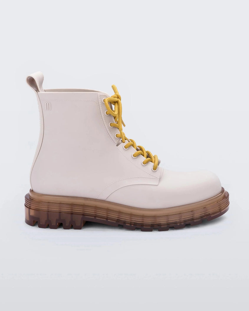 Side view of a matte beige/yellow Melissa Coturno boots with a matte beige base, yellow laces and a brown sole.
