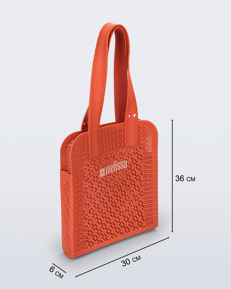 Angled view of an orange Harper bag with shoulder straps with bag measurements of 30cm x 6cm x 36cm