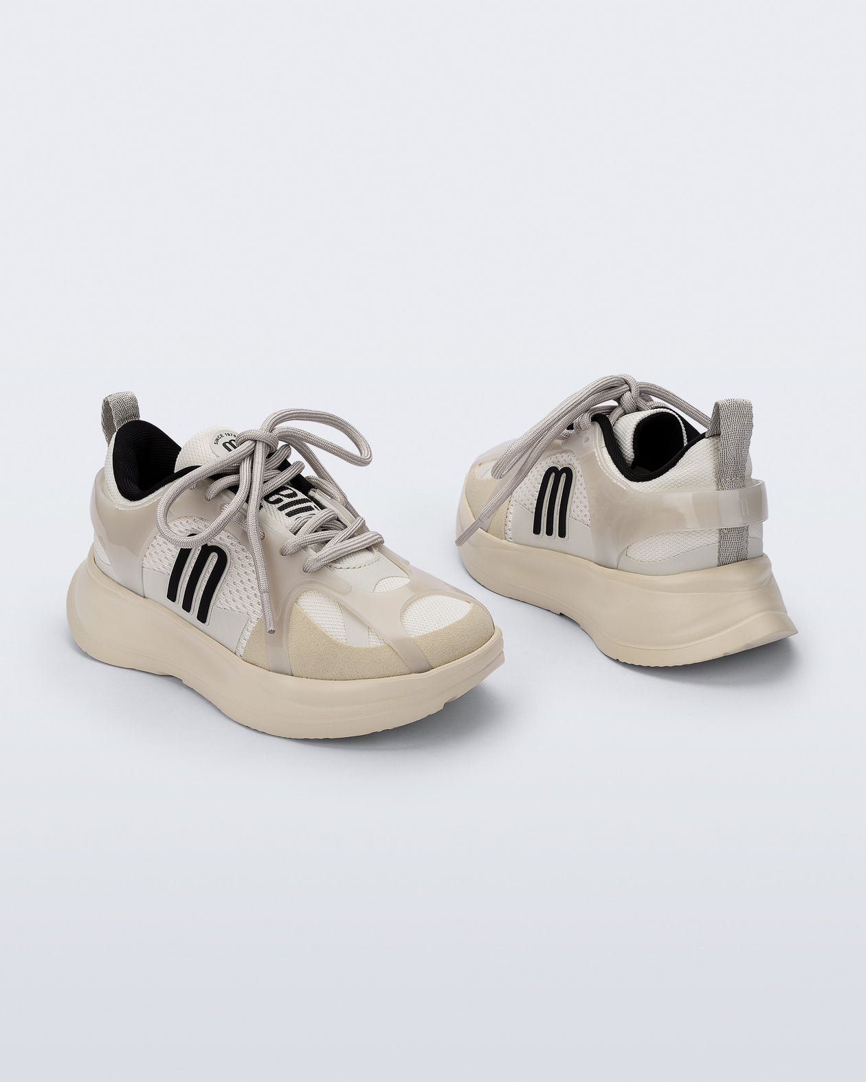 Back and angled view of a pair of off white X Beat kids sneakers with black trim