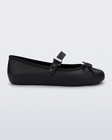 Side view of a black Soft Ballerina Delicate Bow flat with top strap and bow