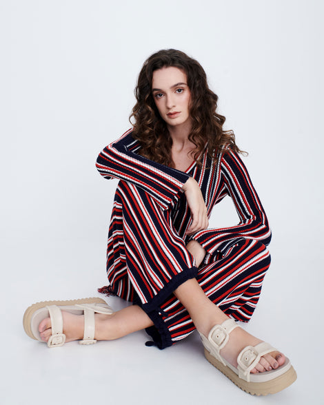 Model in a black and red stripped pant set wearing a pair of beige Cozy Sandal Platforms