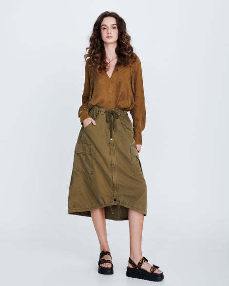 Model in a brown skirt and top wearing a pair of black Cozy Sandal Platforms with clear leopard print straps