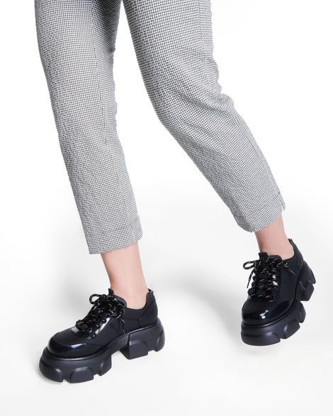 Model's legs wearing a pair of black Camp platform Sneakers with black laces
