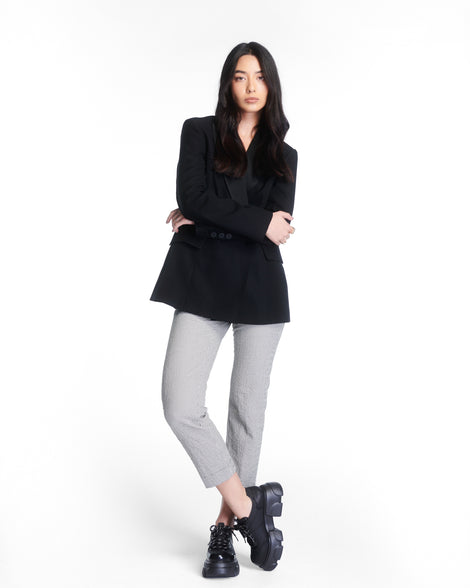 Model in grey capris and black jacket wearing a pair of black Camp platform Sneakers with black laces