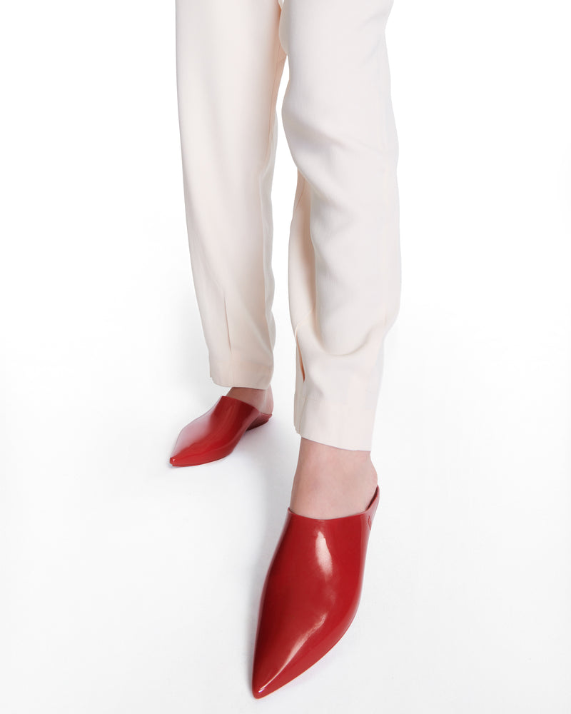 Model's legs wearing a pair of red She slip ons with pointed toe