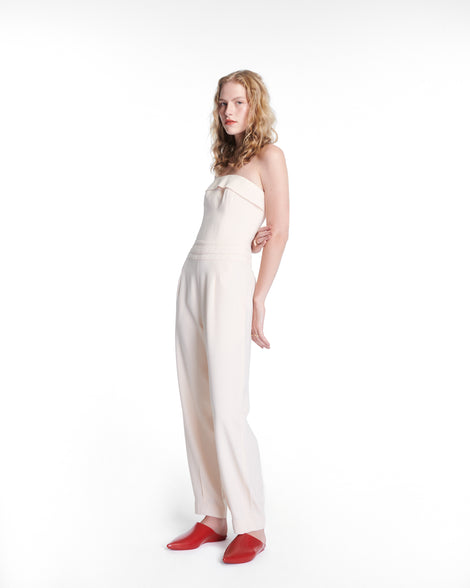 Model in a white outfit wearing a pair of red She slip ons with pointed toe