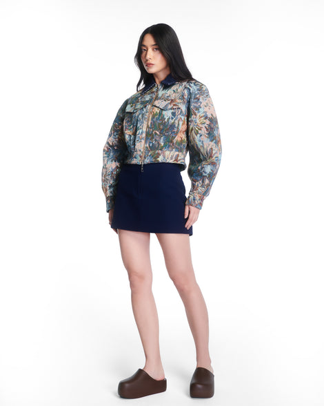 Model in a black skirt and multi colored jacket wearing a pair of brown Free Clog Up Platforms