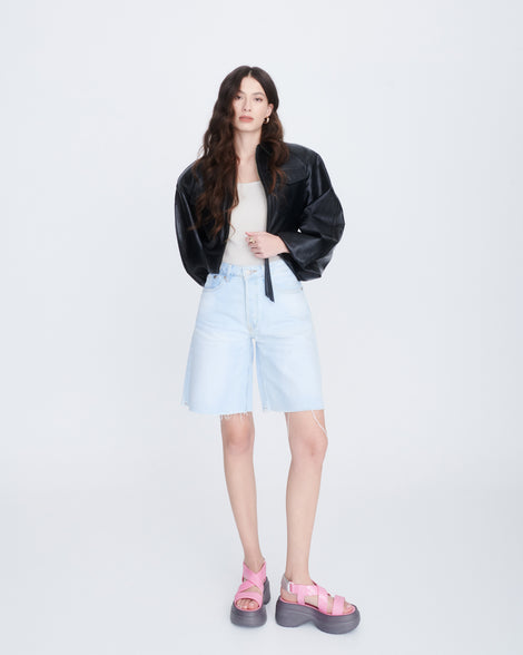 Model in jean shorts wearing a pair of pink Stand platform sandals with dark grey sole