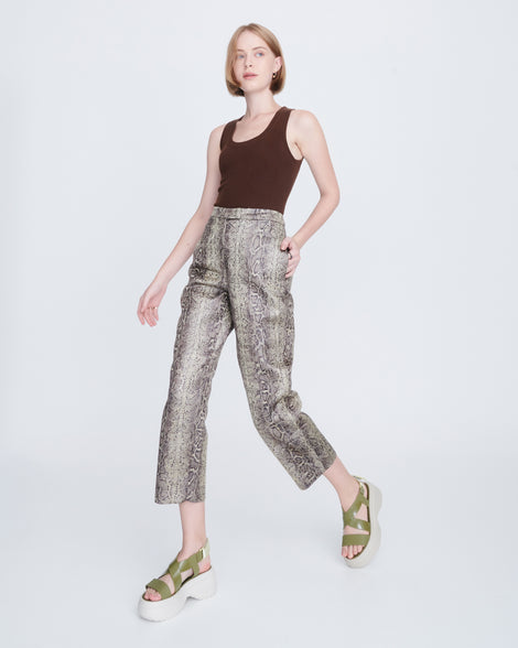 Model in snake print capris and brown tank wearing a pair of beige Stand platform sandals with army green straps