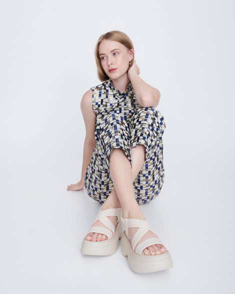 Model in a multi colored pant set wearing a pair of beige Stand platform sandals