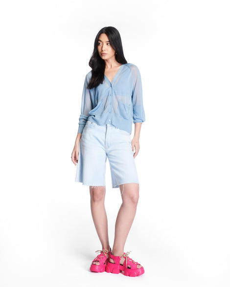 Model in a blue shirt and jean shorts wearing a pair of pink Camp platform sandals with beige laces and accents