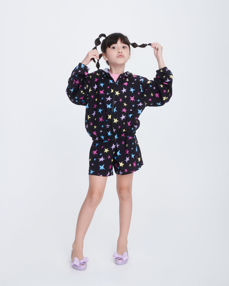 Child model in a black with stars outfit wearing a pair of pearly lilac Ultragirl Classy kids flats with lilac bow