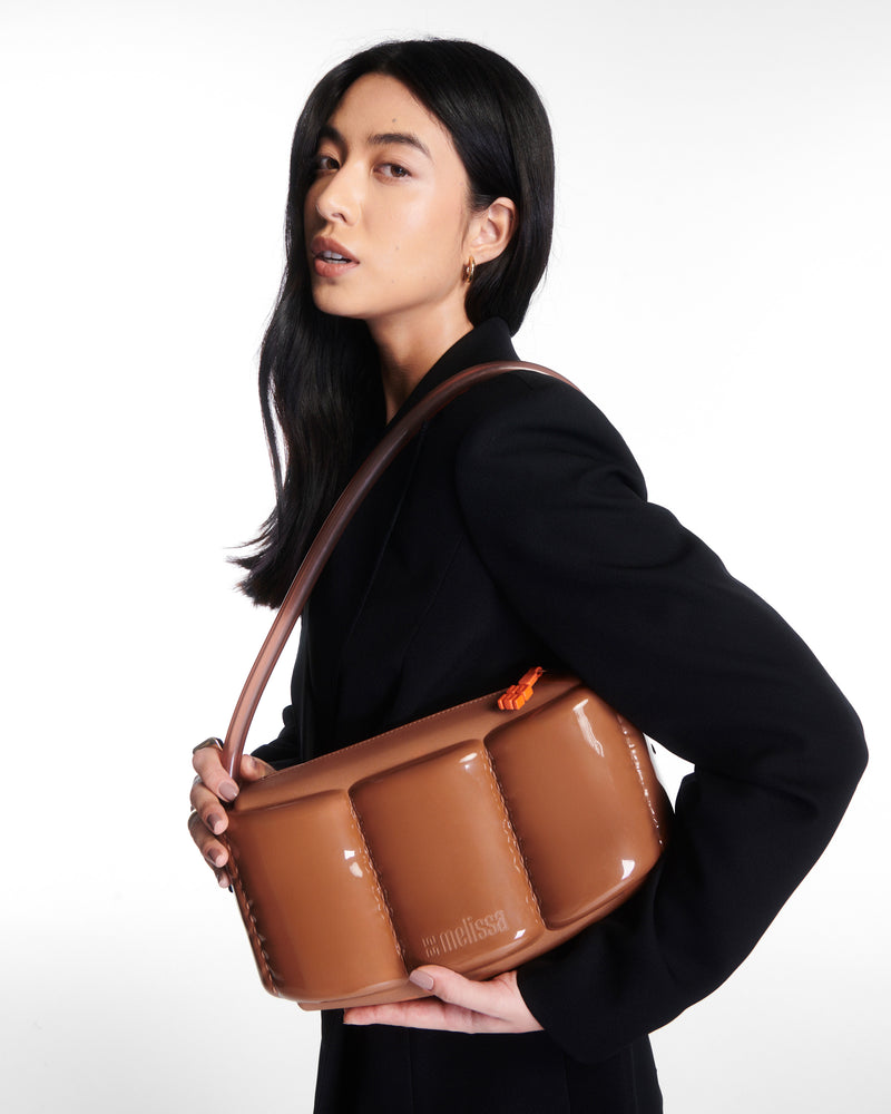 Model holding a brown Airflow Bag
