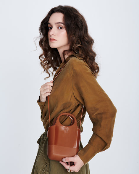 Model with a light brown Ultra Bag using the cross body strap