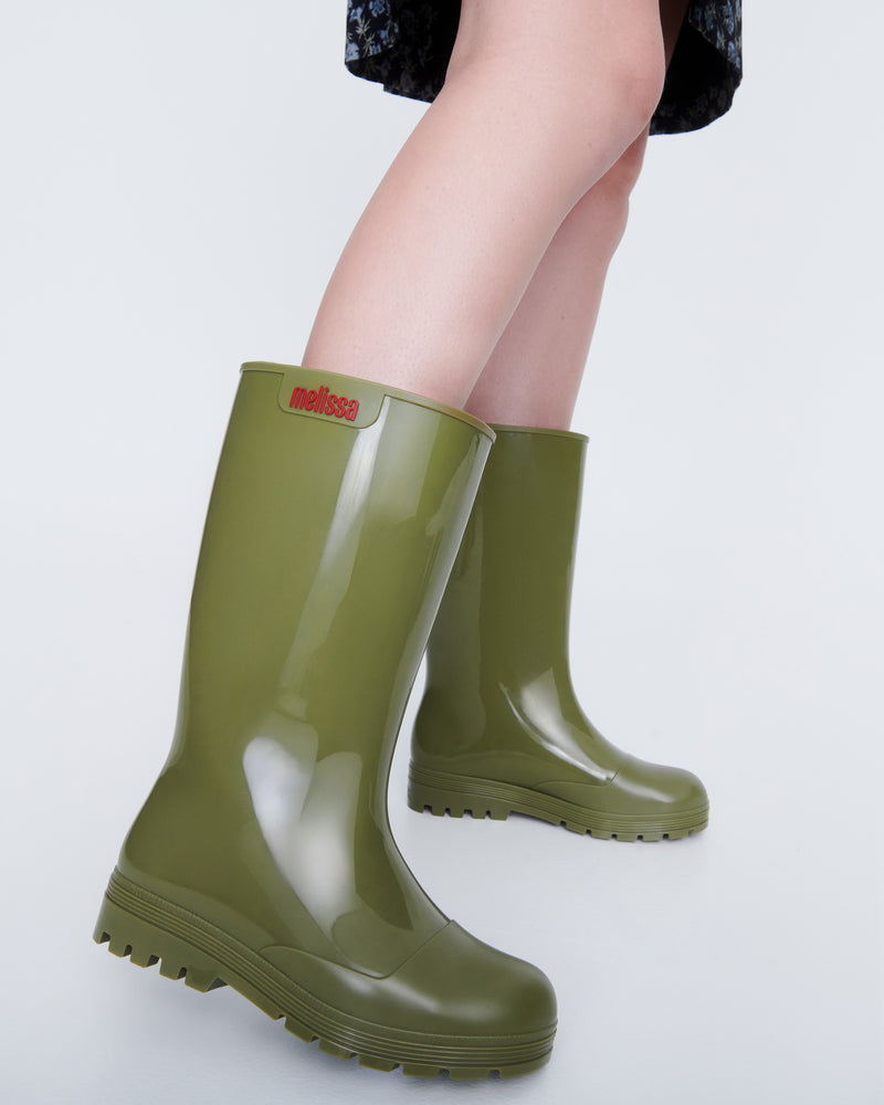 Model's legs wearing a pair of army green Welly rain boots