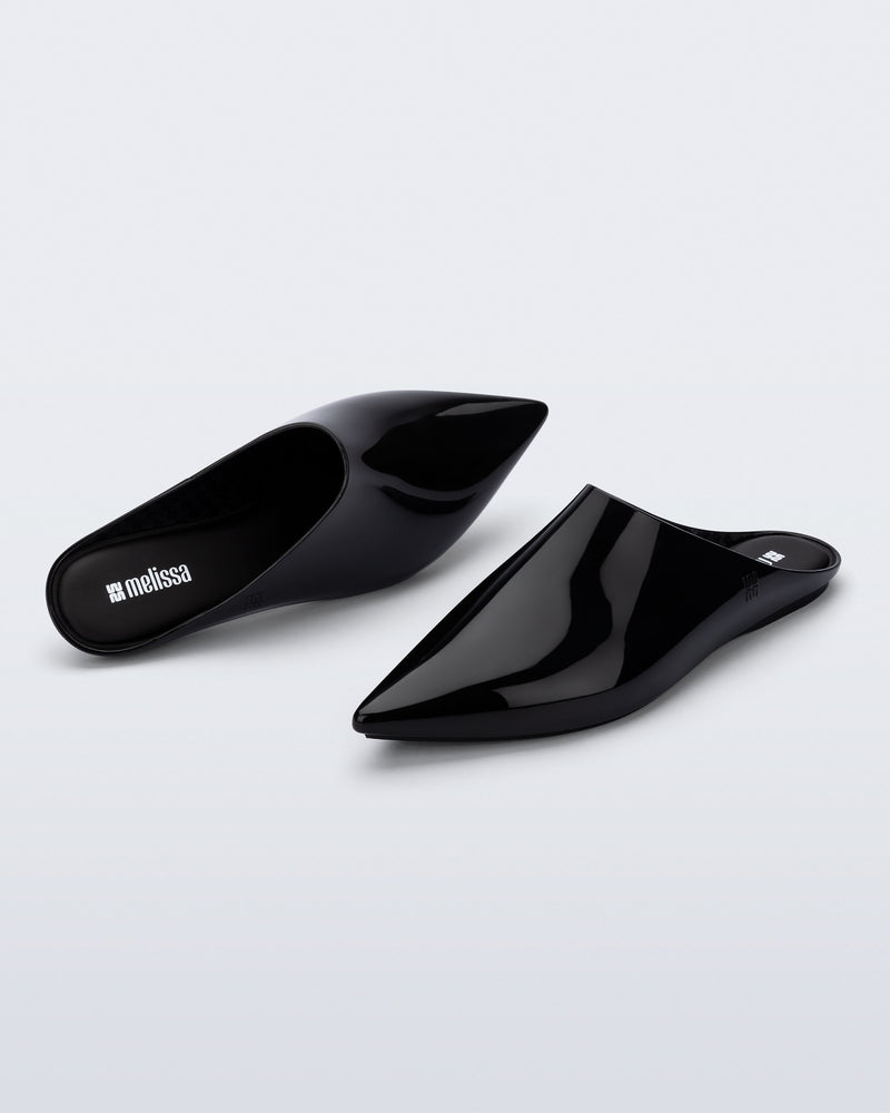 Top and angled view of a pair of black She slip ons with pointed toe