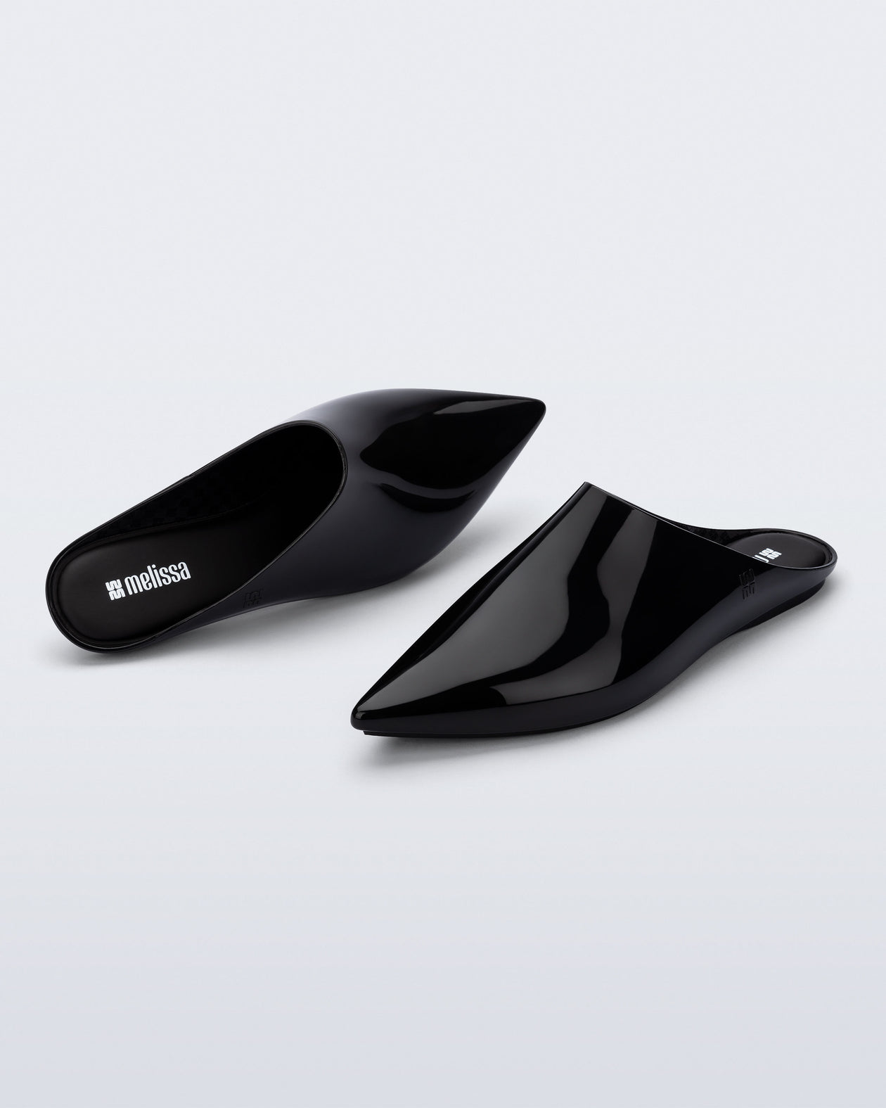 Top and angled view of a pair of black She slip ons with pointed toe