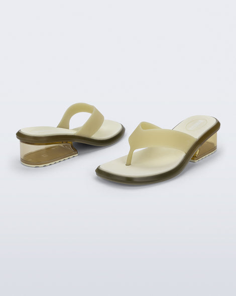 Back and angled view of a pair of beige Margot flip flops with clear beige low heel 