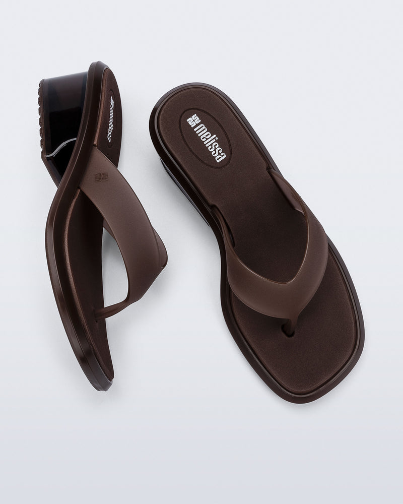 Top and side view of a pair of brown Margot flip flops with low heel 