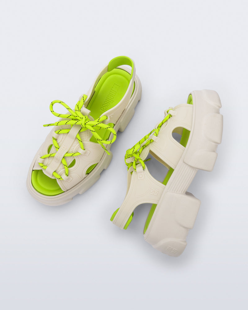 Top and side view of a pair of beige Camp platform sandals with neon green laces and accents