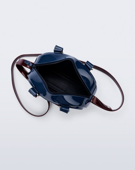 Top view of a blue Bowling bag with burgundy handle strap and cross body strap
