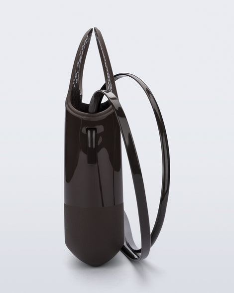 Side view of a brown Ultra Bag with handle and strap