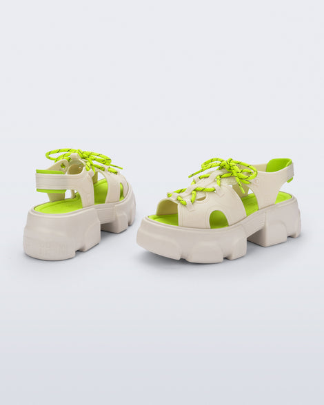 Back and angled view of a pair of beige Camp platform sandals with neon green laces and accents