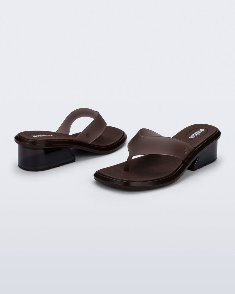 Back and angled view of a pair of brown Margot flip flops with low heel 