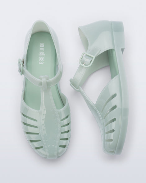 Top and side view of a pair of milky green Aranha 79 flats with buckle