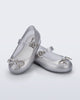 Angled view of a pair of Silver Sweet Love Chrome baby flats with metallic silver bow and buckle