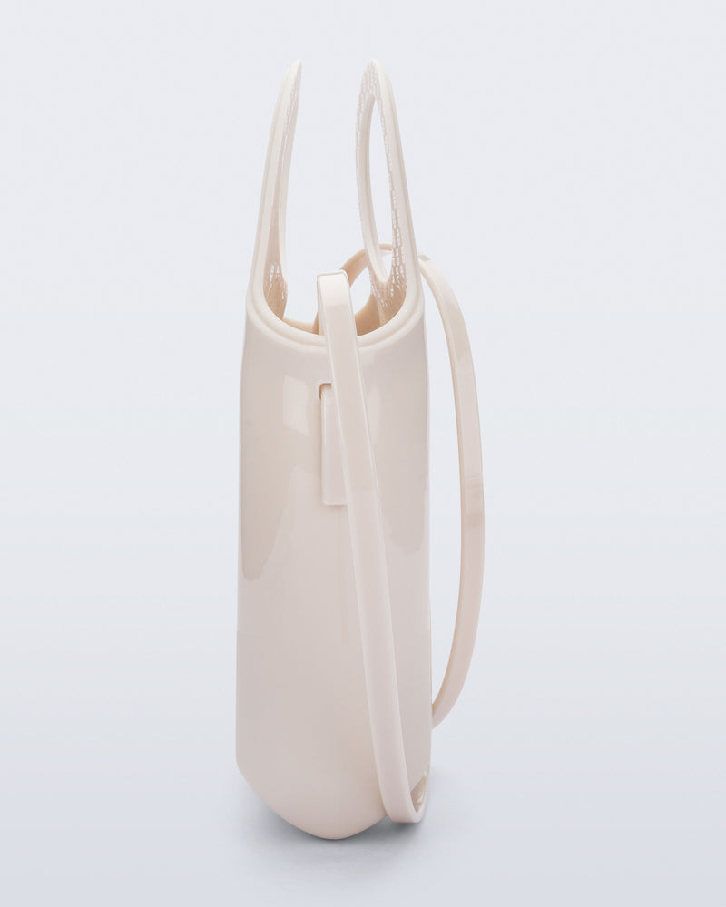 Back view of a beige Ultra Bag with handle and strap