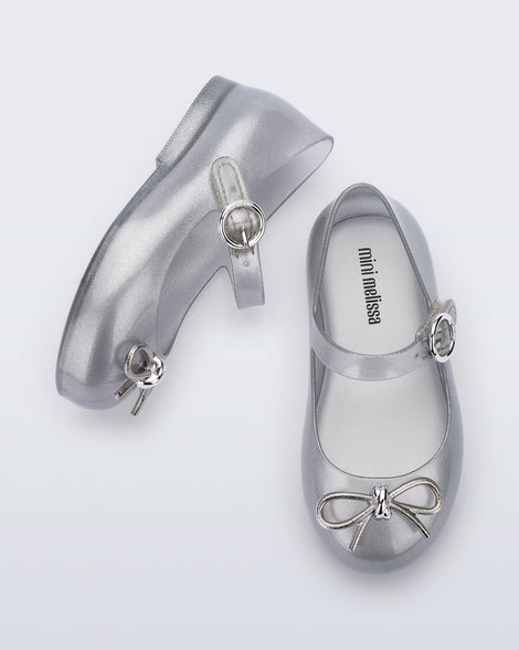 Top and side view of a pair of silver Sweet Love Chrome baby flats with metallic silver bow and buckle