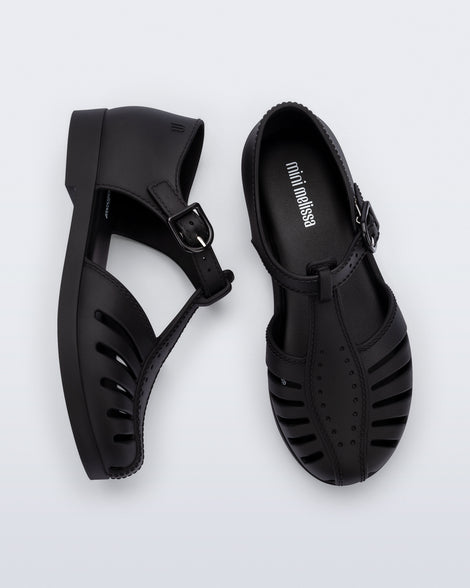 Side and top view of a pair of black Aranha 79 kids flats with buckle