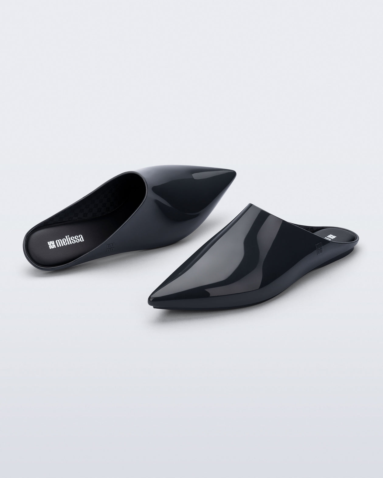 Top and angled view of a pair of grey She slip ons with pointed toe