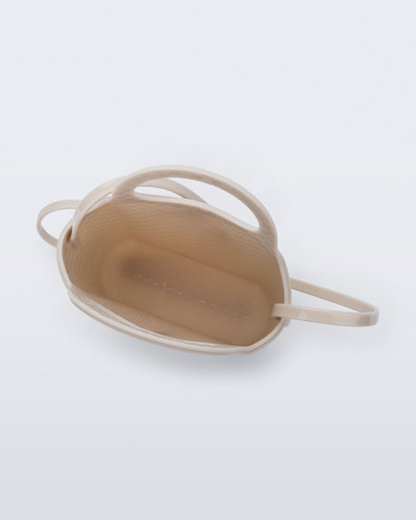 Top view of a beige Ultra Bag with handle and strap