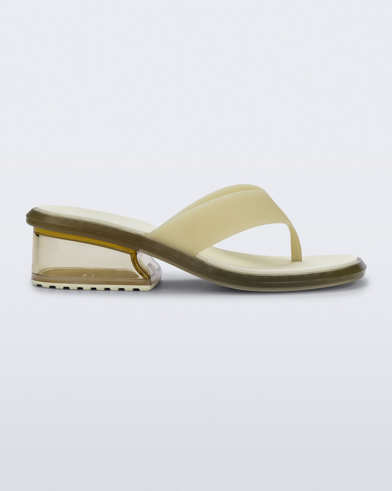 Side view of a beige Margot flip flop with clear beige low heel 