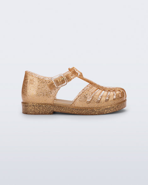 Side view of a glitter gold Aranha 79 baby flat with buckle