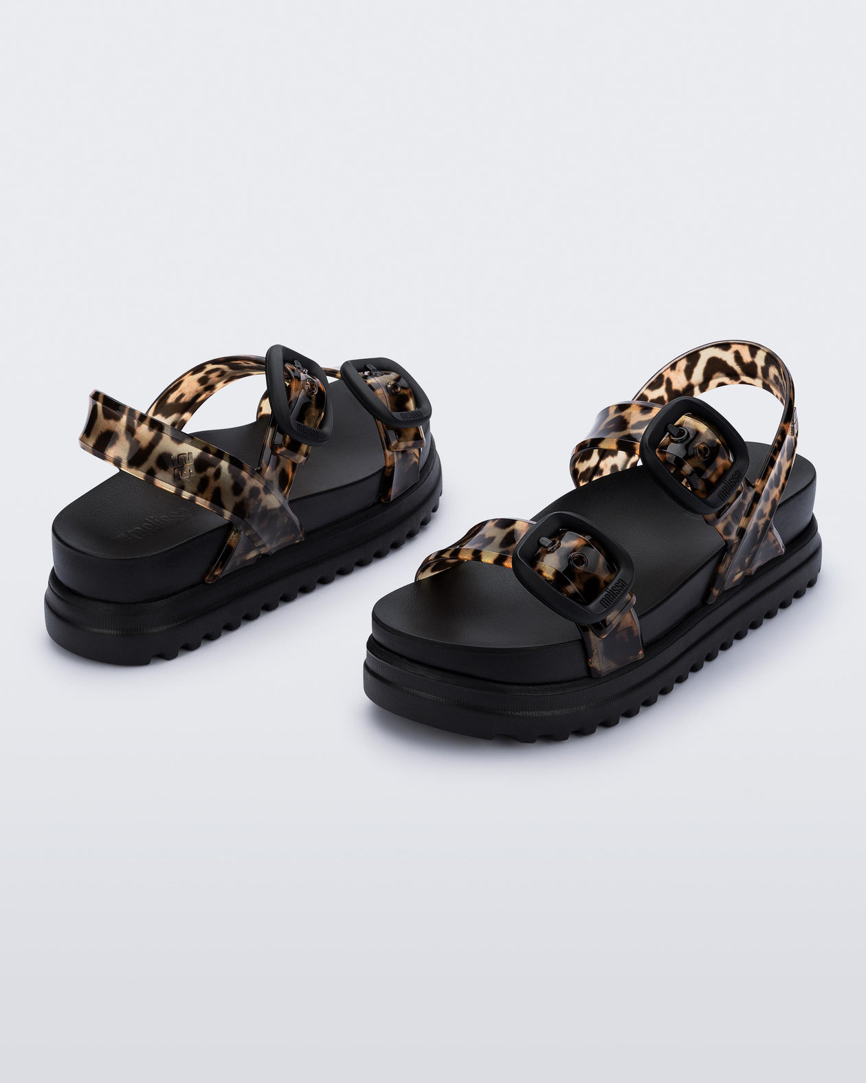 Back and angled view of a pair of black Cozy Sandal Platforms with clear leopard print straps