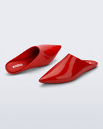 Top and angled view of a pair of red She slip ons with pointed toe