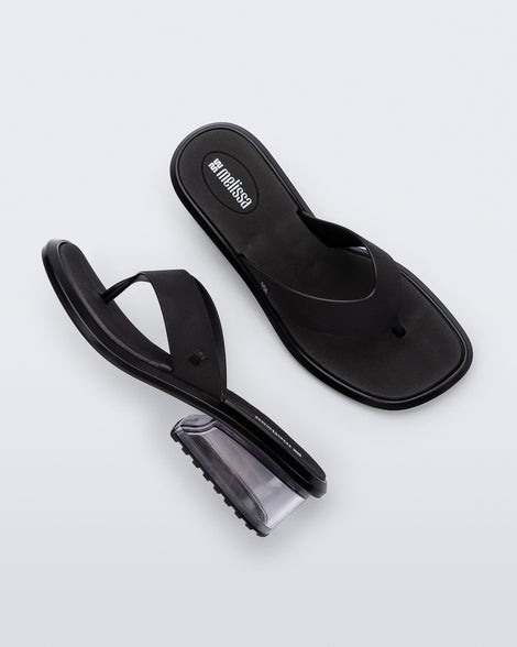Top and side view of a pair of black Margot flip flops with clear  low heel 