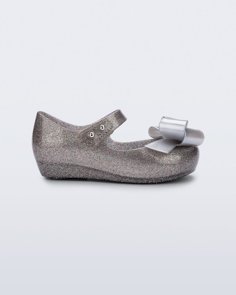 Side view of a silver glitter Ultragirl Classy baby flat with silver bow