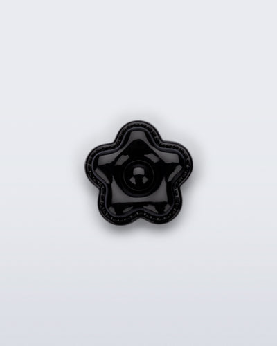 Front view of a black flower shoe charm