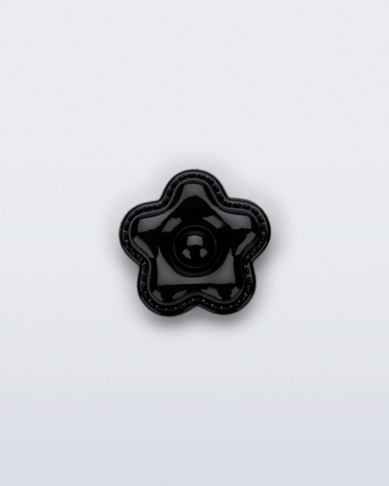 Front view of a black flower shoe charm