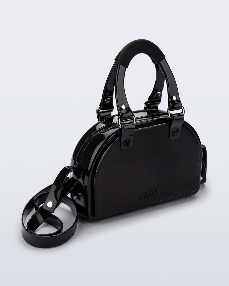 Angled view of a black Bowling bag with handle straps and cross body strap