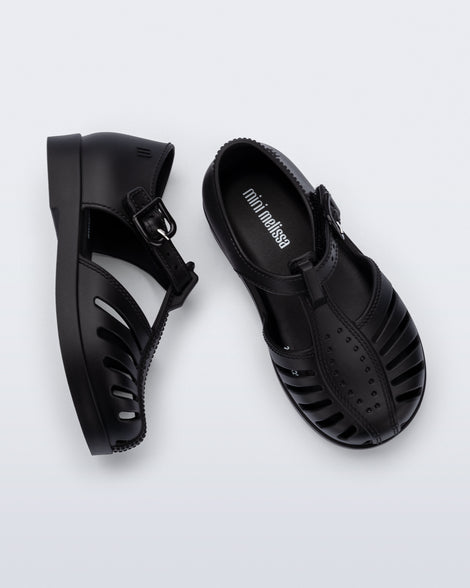 Side and top view of a pair of black Aranha 79 baby flats with buckle