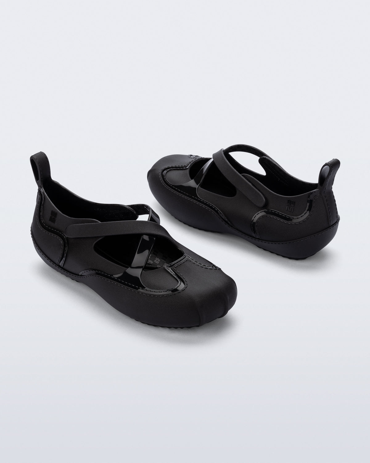 Back and angled view of a pair of black Aira flats with top straps