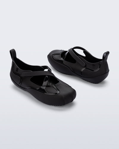 Back and angled view of a pair of black Aira flats with top straps