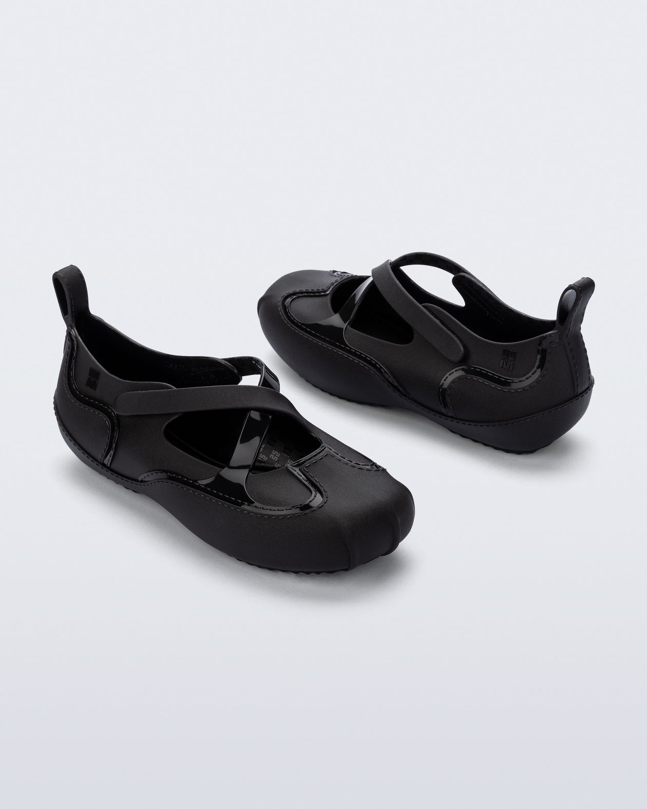 Back and angled view of a pair of black Aira flats with top straps