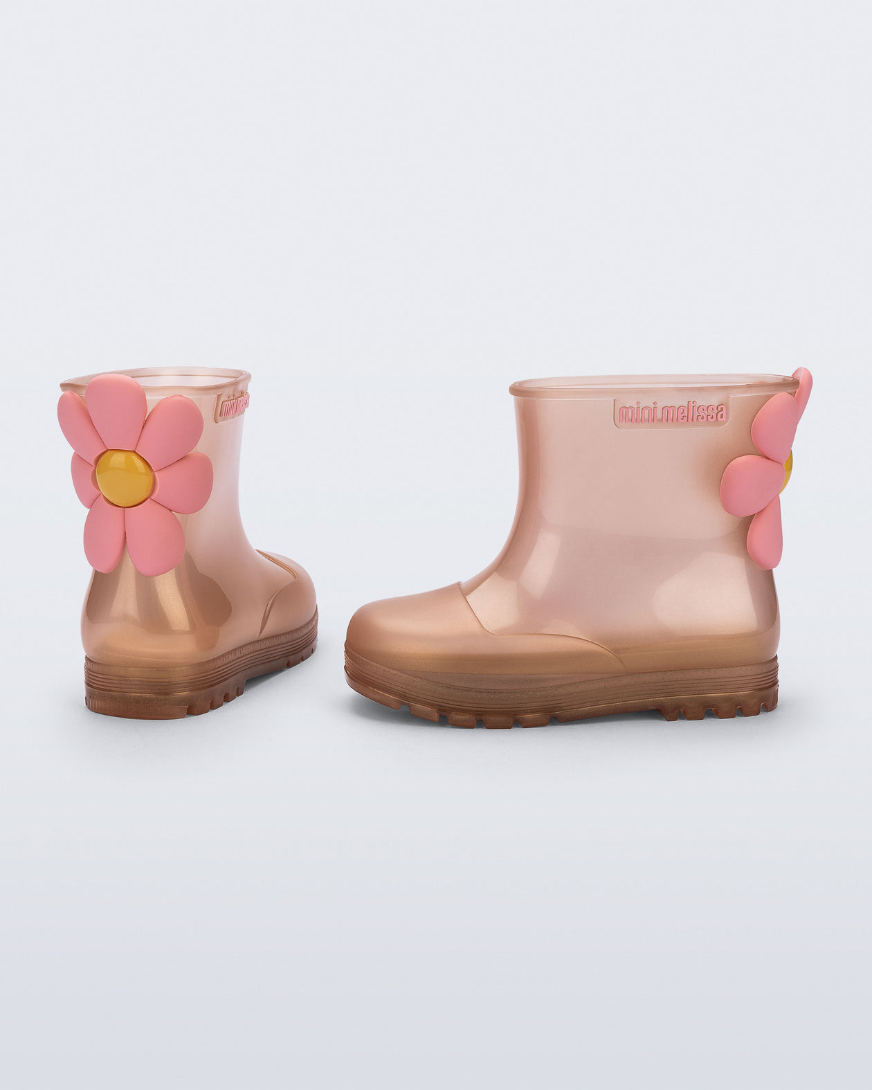 Side and back view of a pair of pearly pink Welly Bloomy boots with pink daisy on back